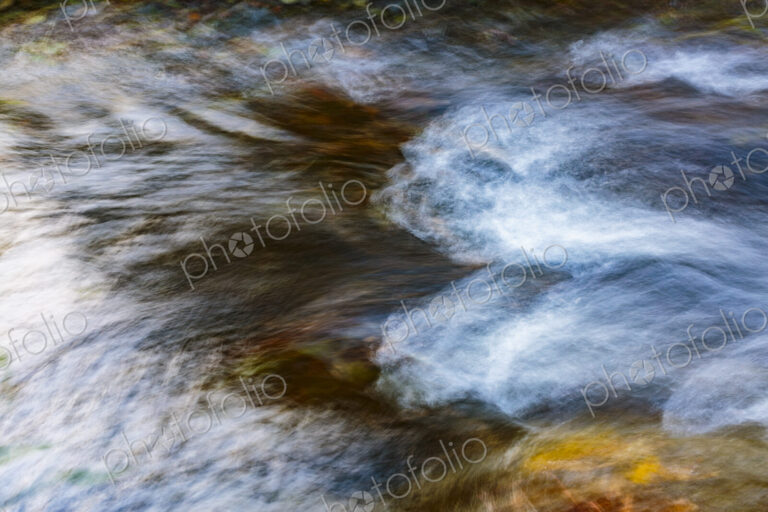 Motion blurred water flowing over stones in the Lyre River, Olympic Peninsula, Joyce,…