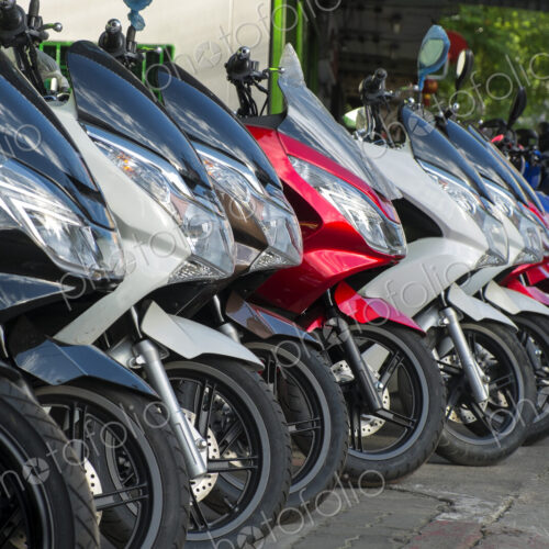 Motorcycles parked in a row on sidewalk. Motorcycles parked in a row on sidewalk.
