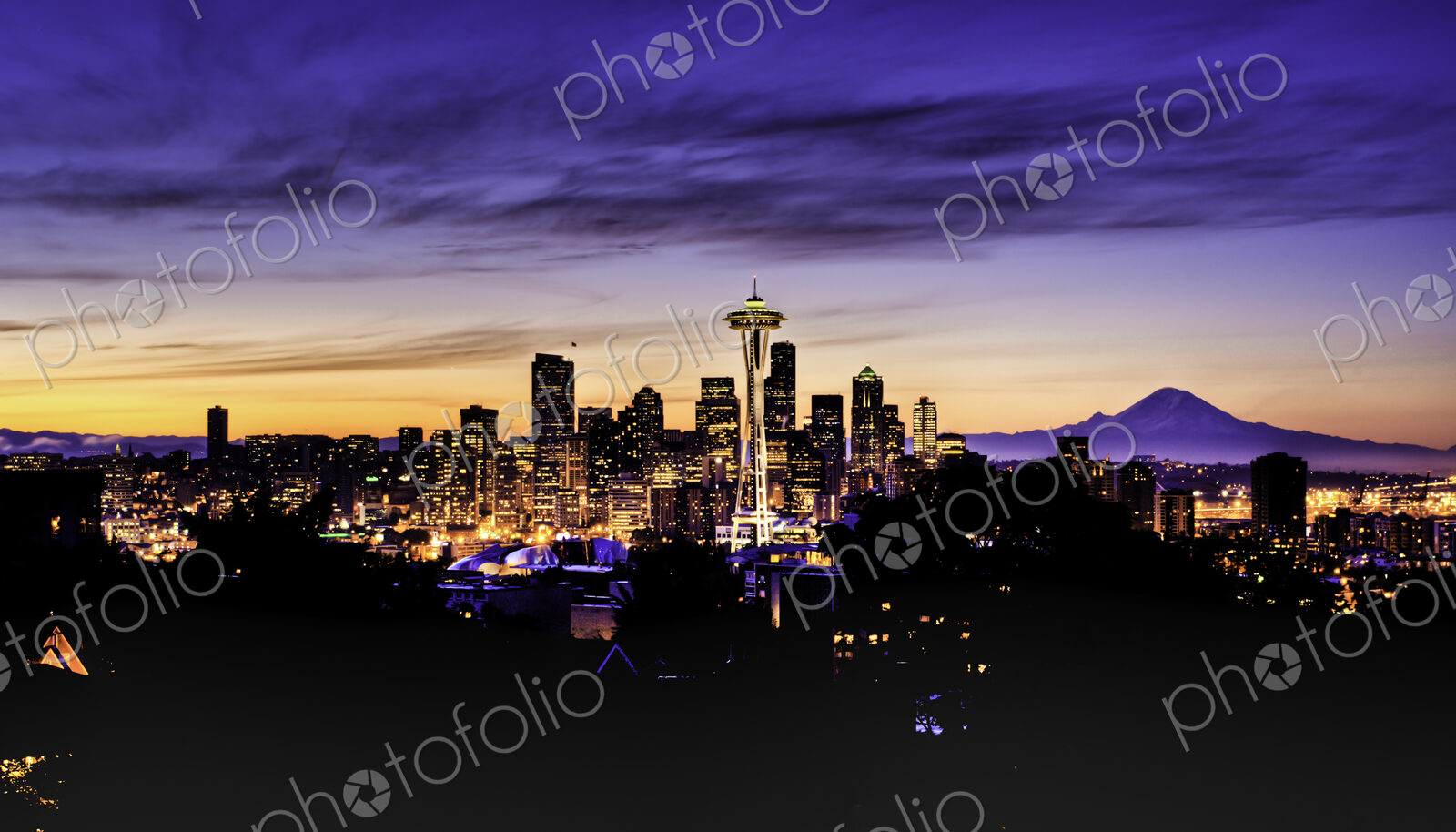 Mount Rainer seen behind modern Seattle skyline in a colourful winter dawn.