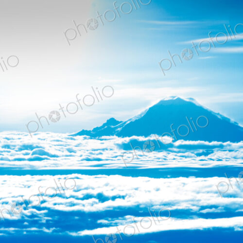 Mount Rainier summit appearing about the clouds, a view from a jetliner window. Mount Rainier summit appearing about the clouds, a view from a jetliner window.