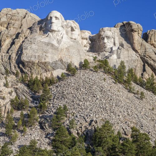 Mount Rushmore with four presidential sculptures carved in granite above pine forest… Mount Rushmore with four presidential sculptures carved in granite above pine forest…