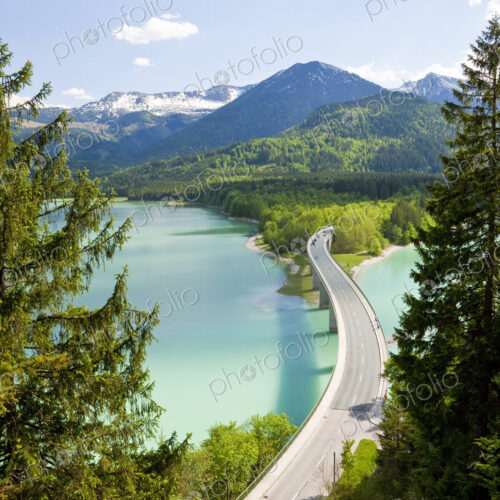 Mountain landscape with forests and bridge crossing dam in the foreground. Mountain landscape with forests and bridge crossing dam in the foreground.