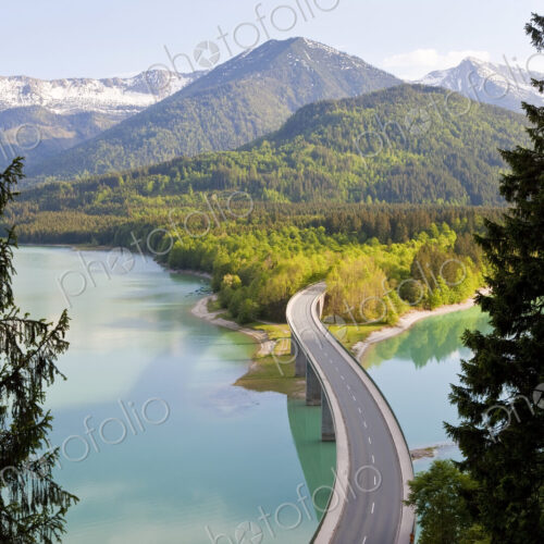 Mountain landscape with forests and bridge crossing dam in the foreground. Mountain landscape with forests and bridge crossing dam in the foreground.
