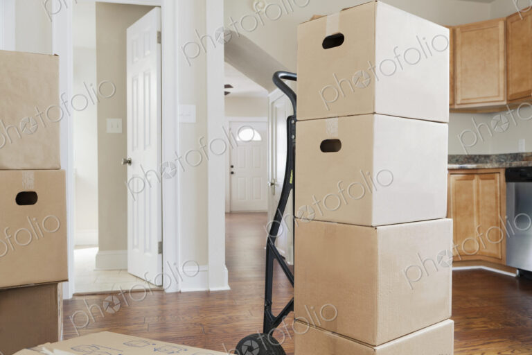 Moving house, relocation, cardboard boxes piled up in a house