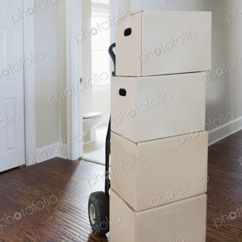 Moving house, relocation, cardboard boxes piled up in a house