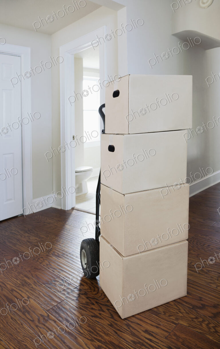 Moving house, relocation, cardboard boxes piled up in a house