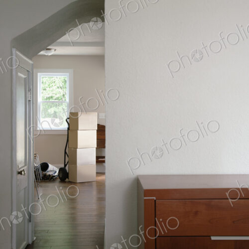 Moving house, relocation, cardboard boxes piled up in a house