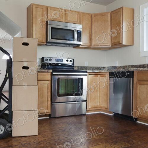 Moving house, relocation, cardboard boxes piled up in a house fitted kitchen Moving house, relocation, cardboard boxes piled up in a house fitted kitchen