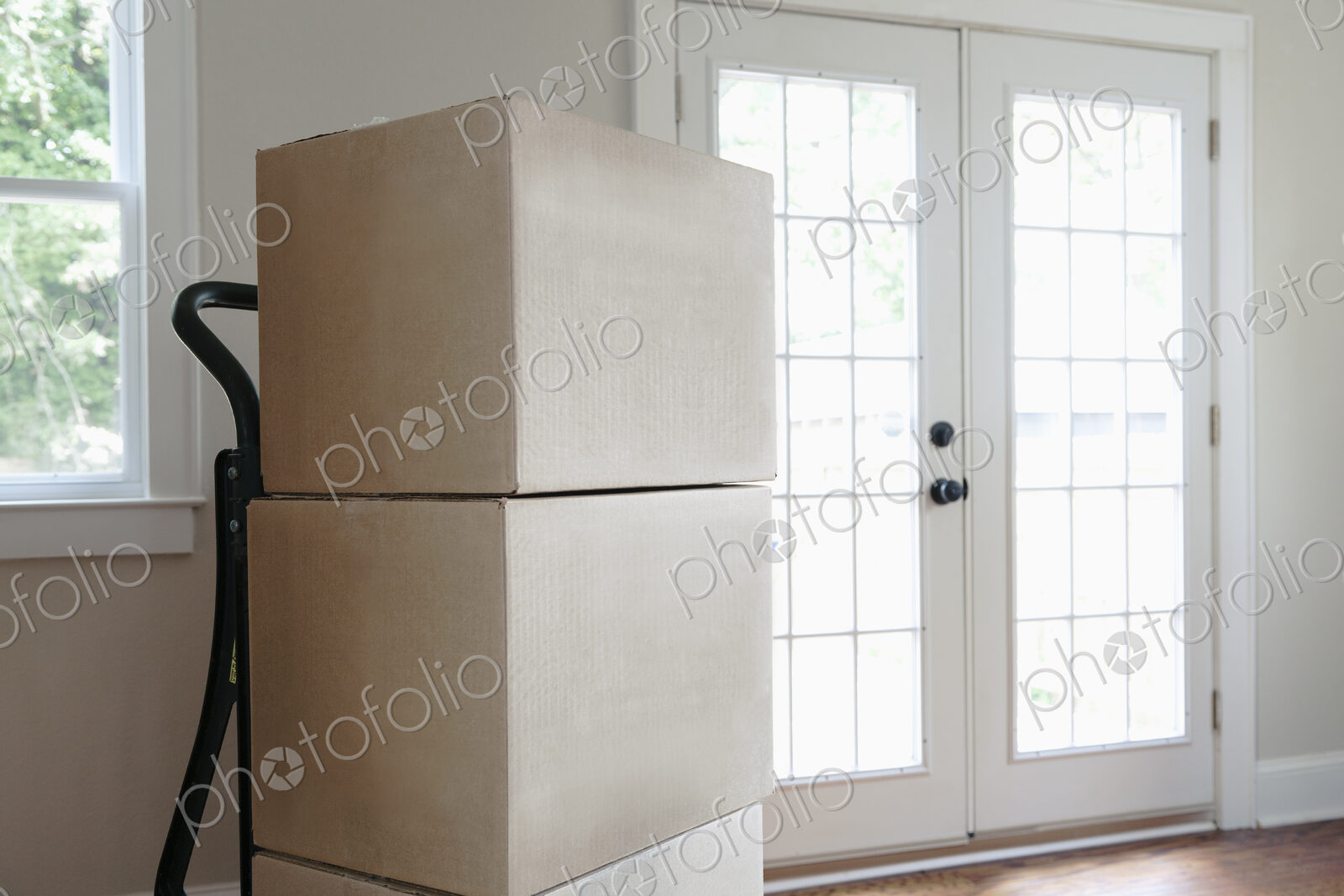 Moving house, relocation, cardboard boxes piled up in an empty house.