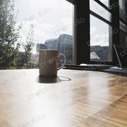 Mug on desk in urban office. Mug on desk in urban office.