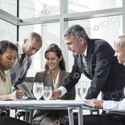 Multi-ethnic group of business people in a meeting at a conference table Multi-ethnic group of business people in a meeting at a conference table