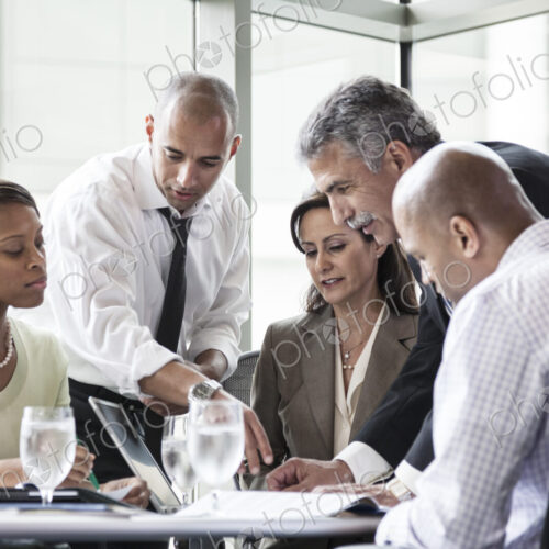 Multi-ethnic group of business people in a meeting at a conference table Multi-ethnic group of business people in a meeting at a conference table