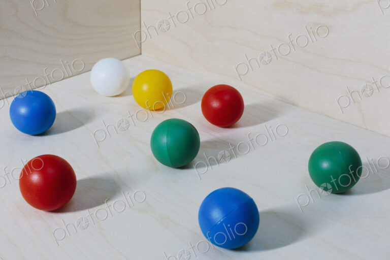 Multicoloured balls arranged on wood background, close up