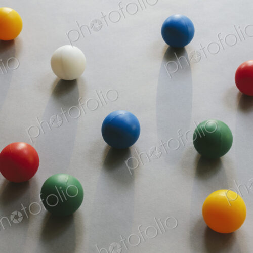 Multicoloured balls arranged on wood background, close up