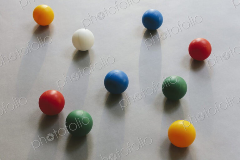 Multicoloured balls arranged on wood background, close up