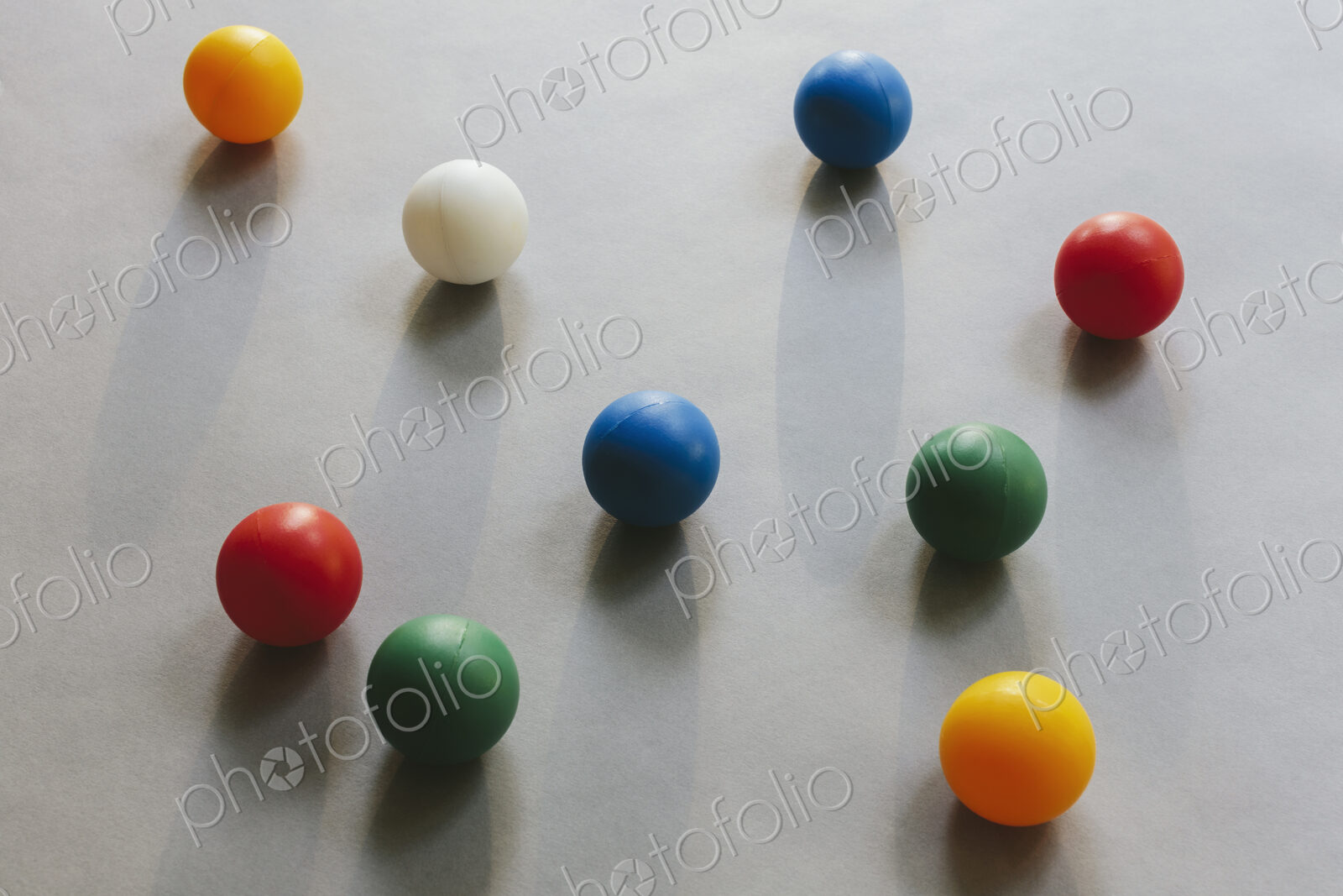 Multicoloured balls arranged on wood background, close up