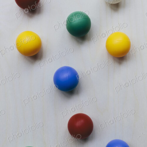 Multicoloured balls arranged on wood background, close up Multicoloured balls arranged on wood background, close up