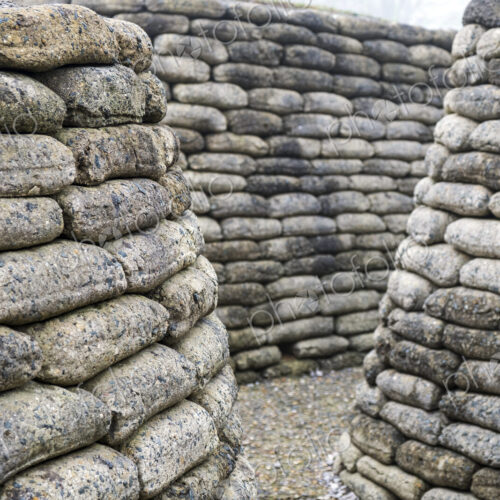 Narrow path in between curved walls of rounded concrete blocks. Narrow path in between curved walls of rounded concrete blocks.