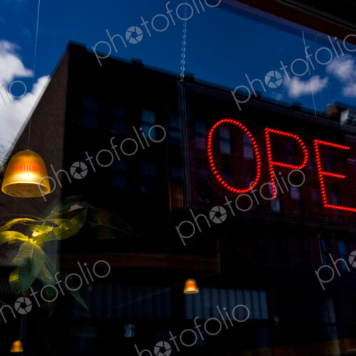 Neon Open sign in window of a business in Seattle, a lamp and plant and reflection of… Neon Open sign in window of a business in Seattle, a lamp and plant and reflection of…