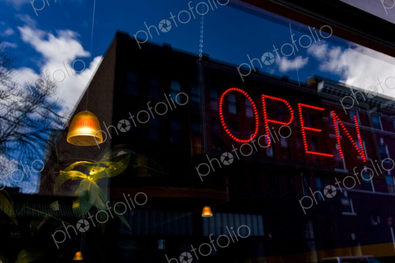 Neon Open sign in window of a business in Seattle, a lamp and plant and reflection of…