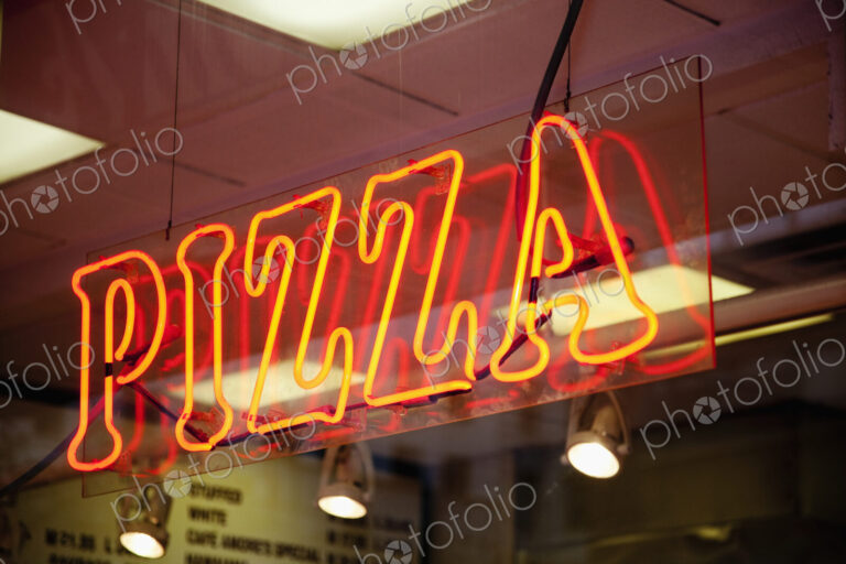 Neon Pizza Sign on Window at Night