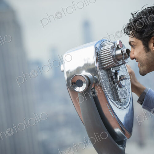 New York City. An observation deck overlooking the Empire State Building. A young man…