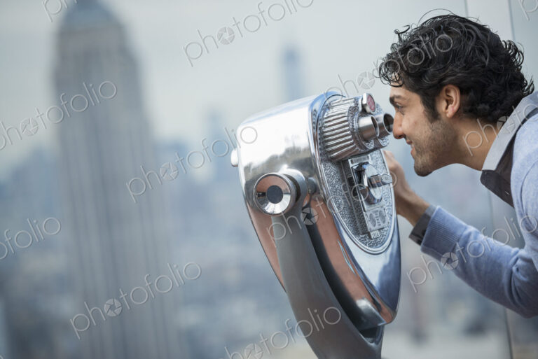 New York City. An observation deck overlooking the Empire State Building. A young man…