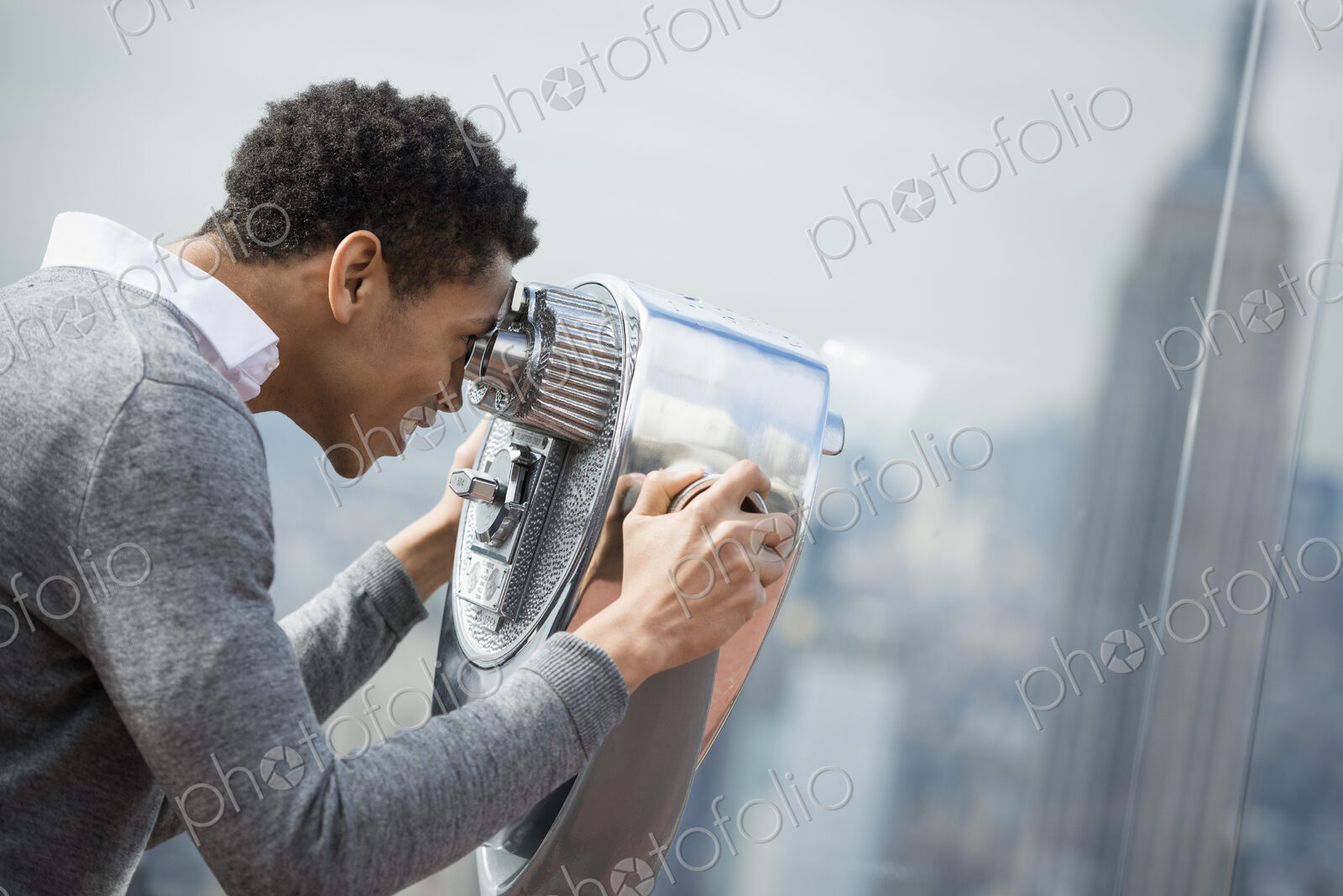 New York City. An observation deck overlooking the Empire State Building. A young man…