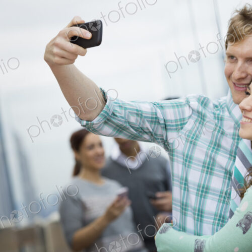 New York City. An observation deck overlooking the Empire State Building. Two couples…