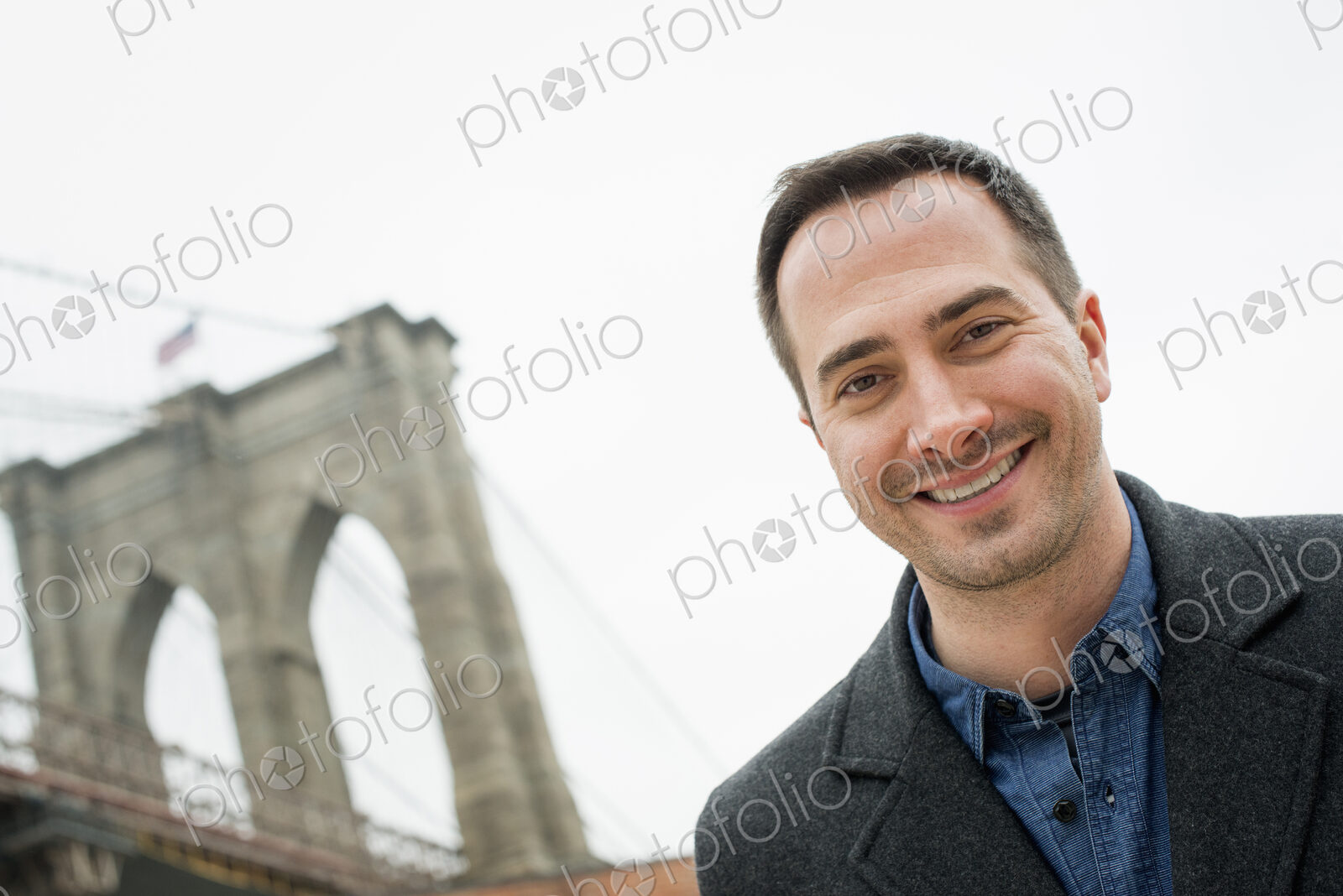 New York city, the Brooklyn Bridge crossing over the East River. A man looking at the…