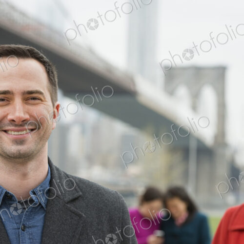 New York city, the Brooklyn Bridge crossing over the East River. Four people, two… New York city, the Brooklyn Bridge crossing over the East River. Four people, two…