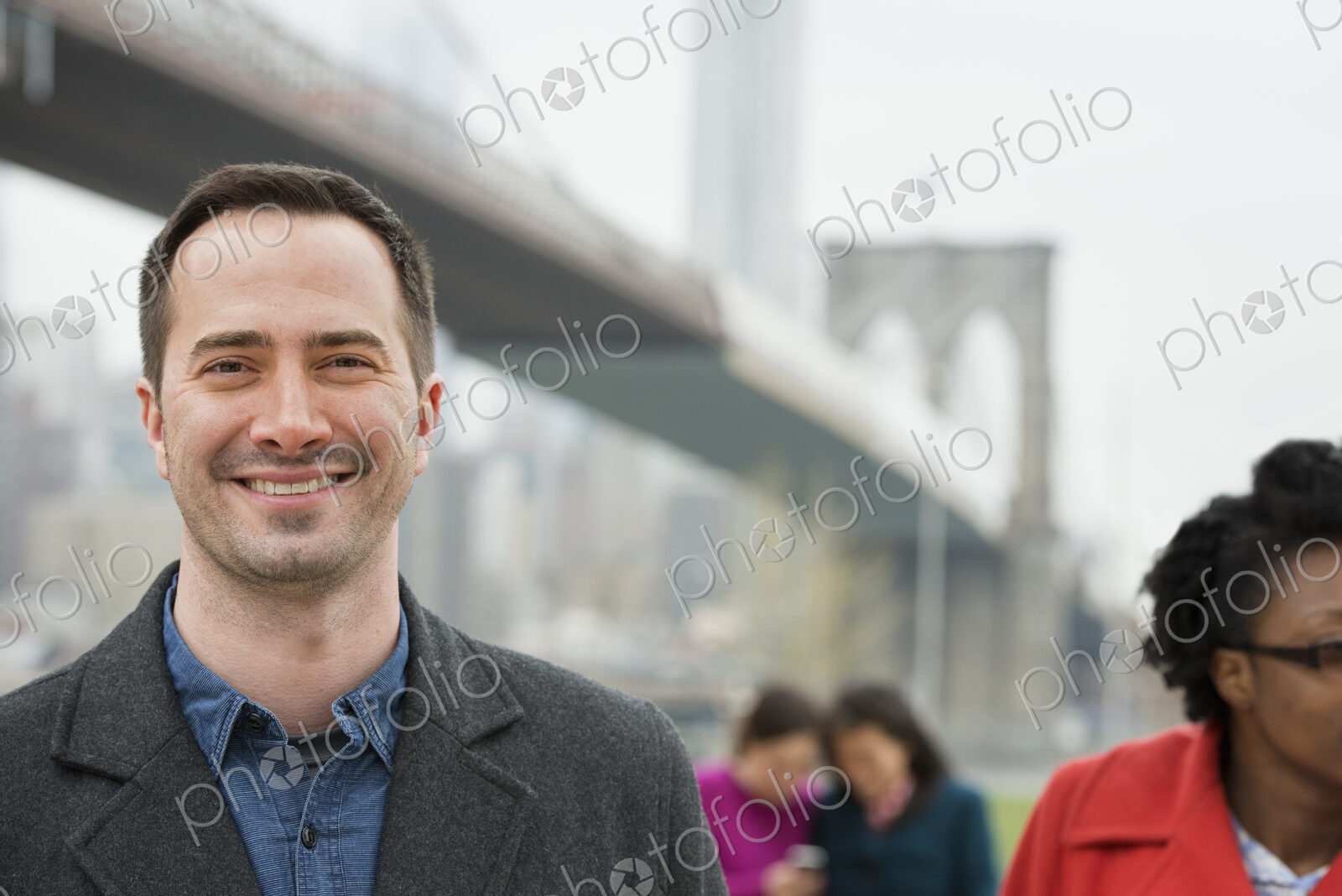 New York city, the Brooklyn Bridge crossing over the East River. Four people, two…
