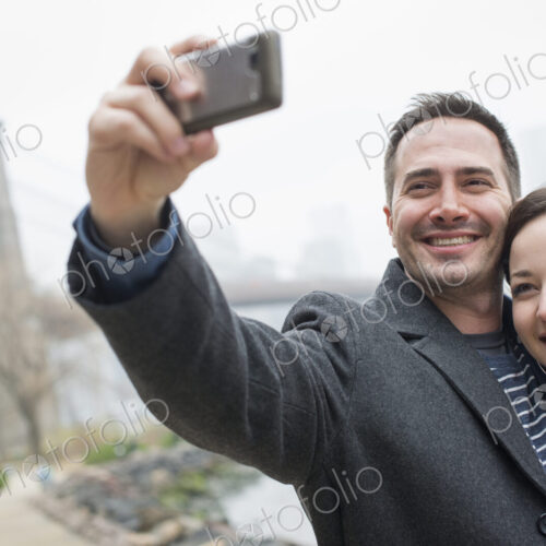 New York city. The Brooklyn Bridge crossing over the East River. A couple taking a… New York city. The Brooklyn Bridge crossing over the East River. A couple taking a…