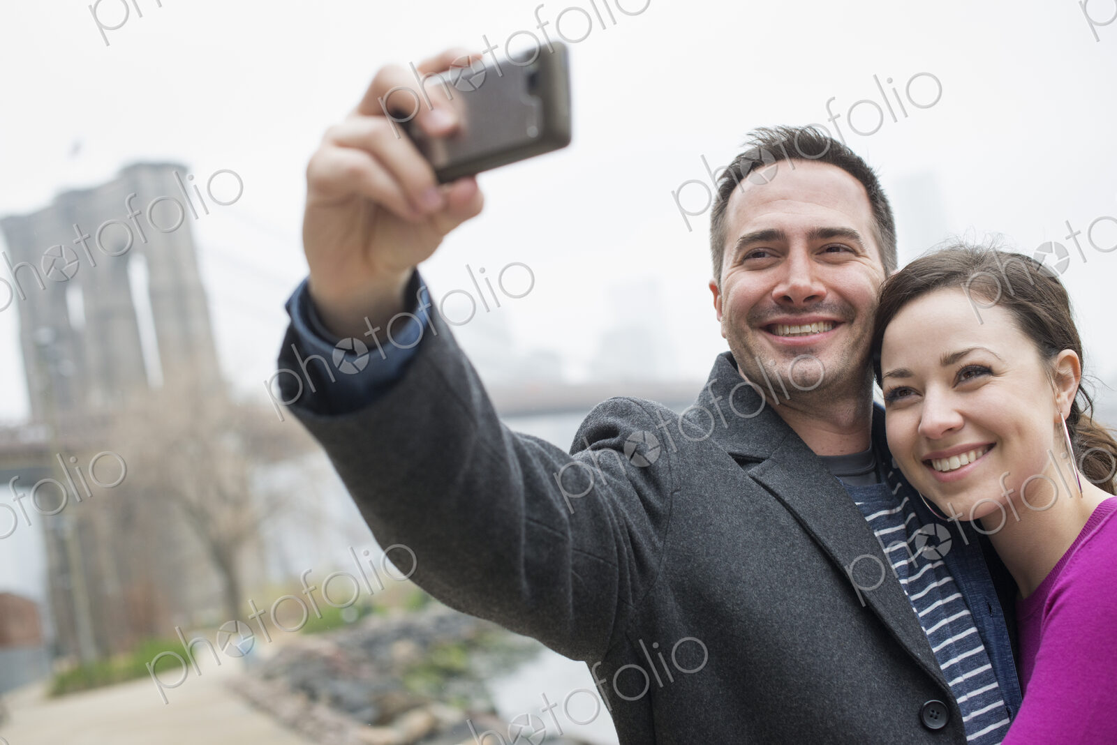 New York city. The Brooklyn Bridge crossing over the East River. A couple taking a…