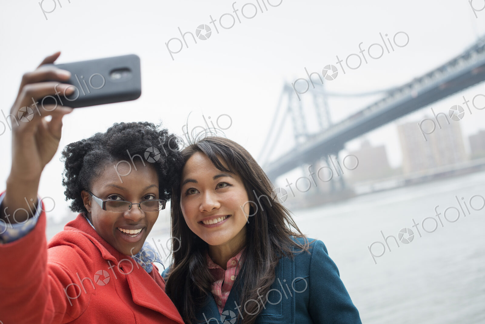 New York city. The Brooklyn Bridge crossing over the East River. A couple, two women,…