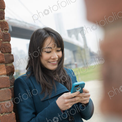 New York city. The Brooklyn Bridge crossing over the East River. A woman leaning… New York city. The Brooklyn Bridge crossing over the East River. A woman leaning…