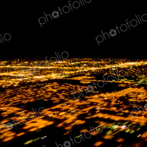 Night aerial of Illuminated urban areas, a cityscape lit up. Night aerial of Illuminated urban areas, a cityscape lit up.