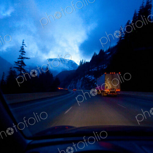 Night highway driving on Snoqualmie Pass, a moonlight sky with clouds, driver's point…