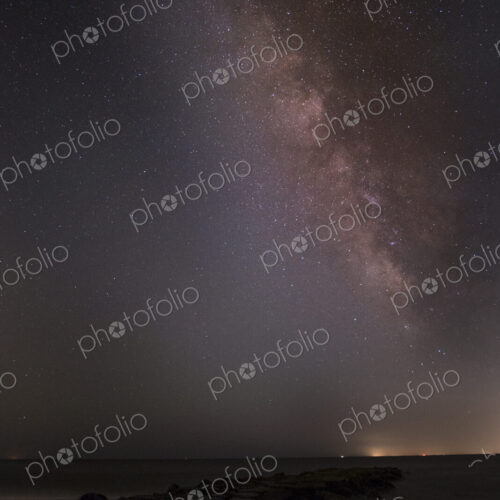 Night sky full of stars above empty flat rural landscape.
