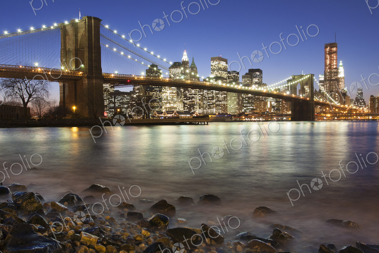Night view towards Manhattan from Brooklyn, with the Brooklyn Bridge spanning the East…