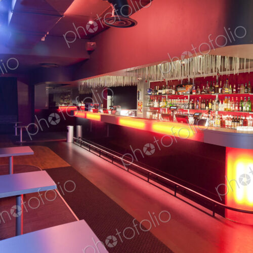 Nightclub interior, hospitality venue and colourful lighting, large bar.