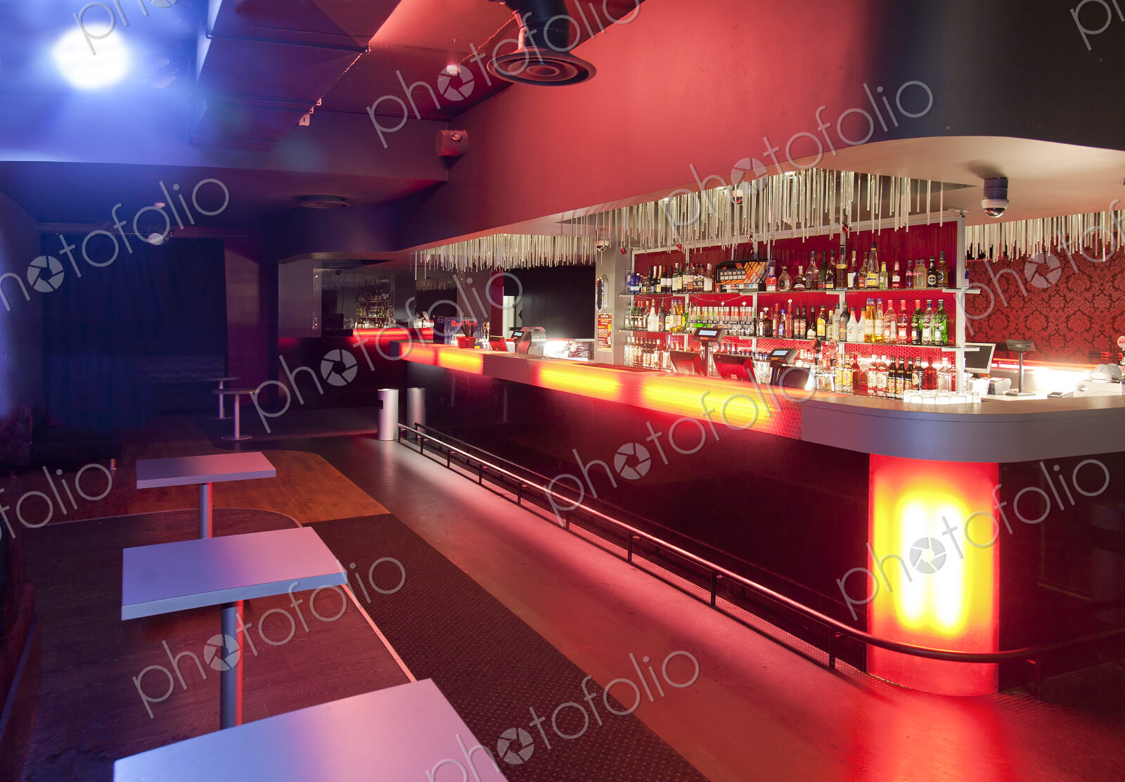 Nightclub interior, hospitality venue and colourful lighting, large bar.