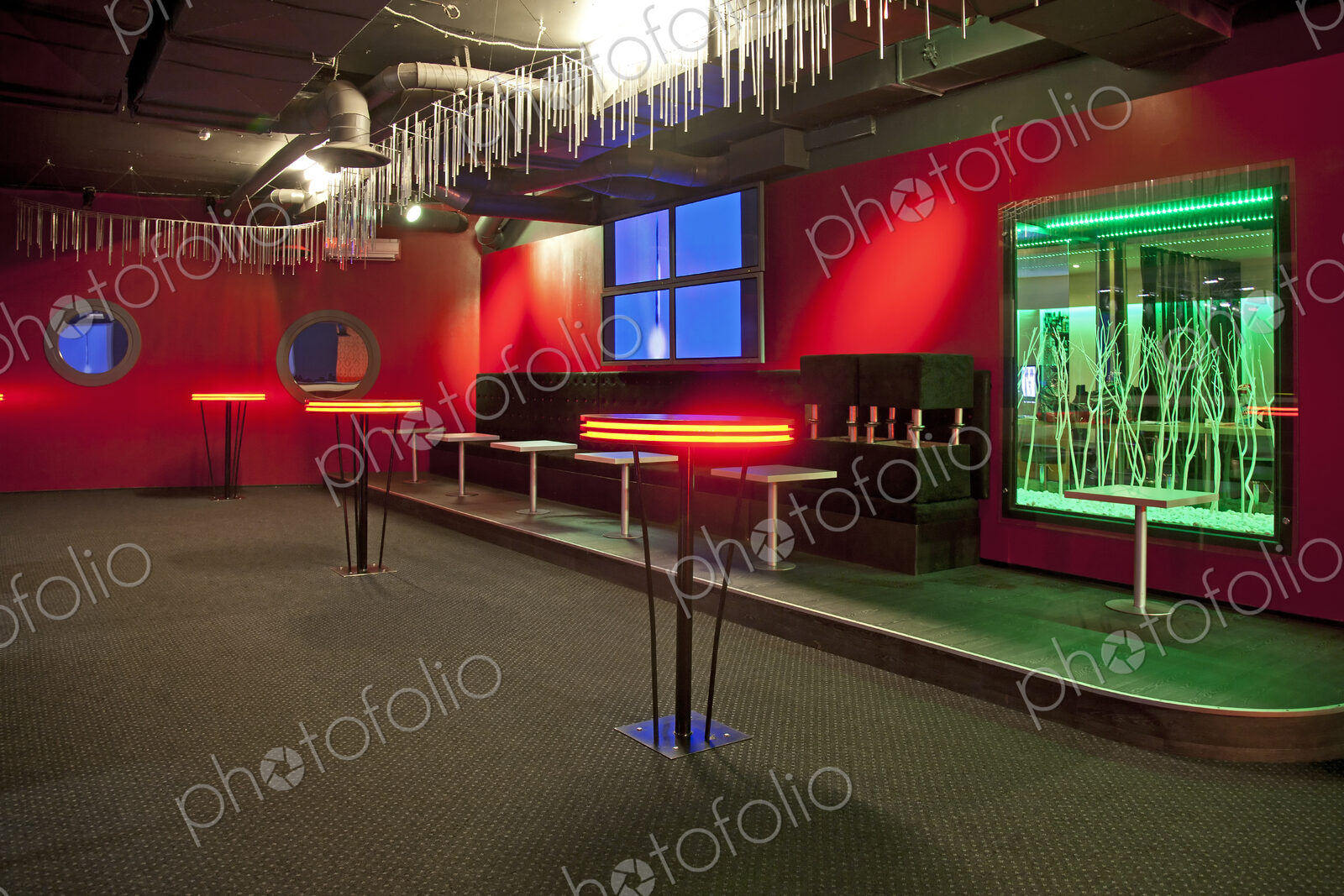 Nightclub interior, hospitality venue and colourful lighting, seatings and tables.