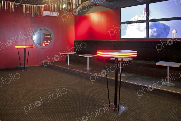 Nightclub interior, hospitality venue and colourful lighting, seatings and tables.