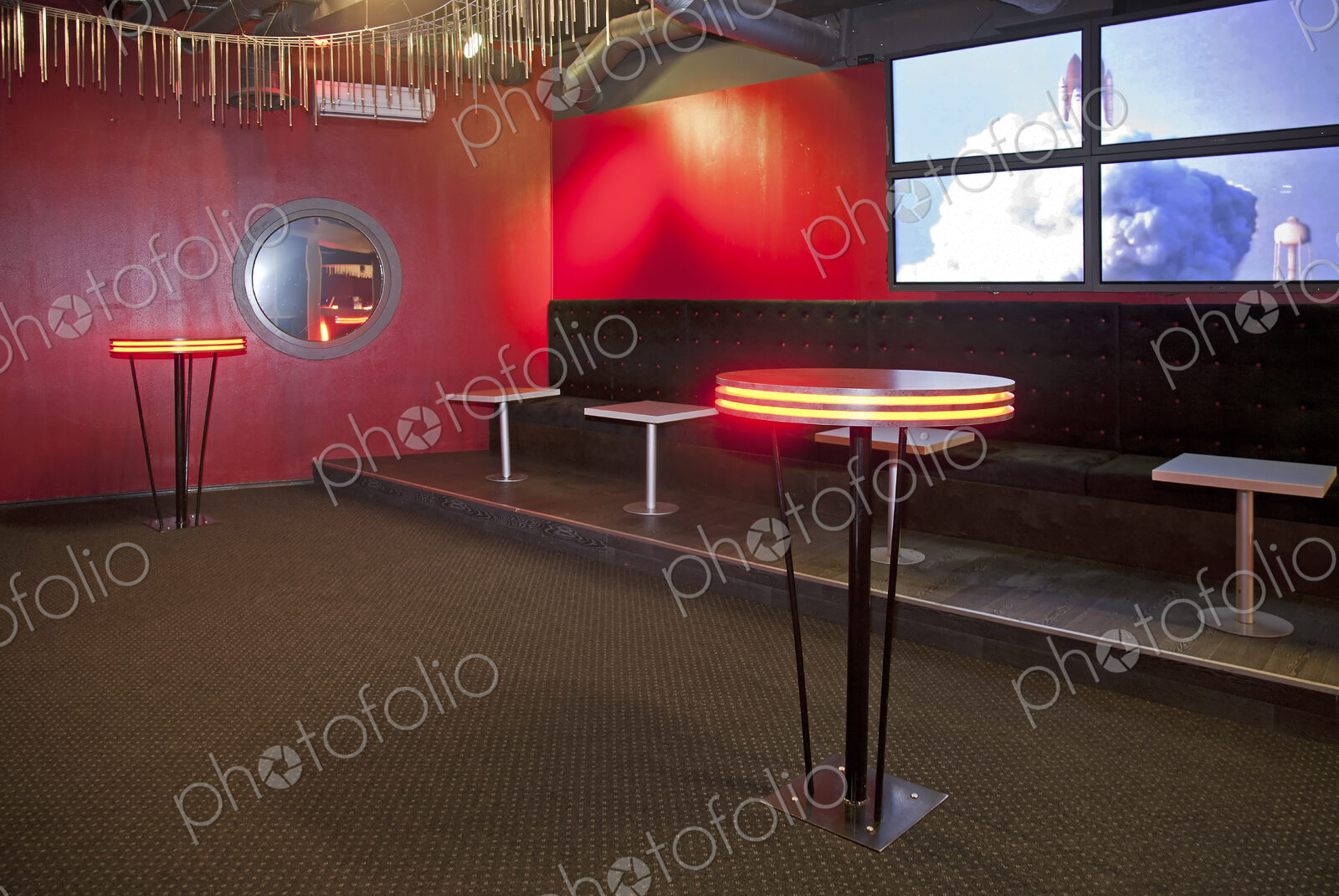 Nightclub interior, hospitality venue and colourful lighting, seatings and tables.