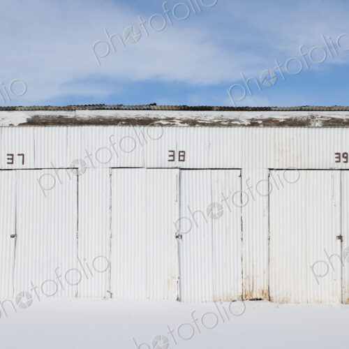 Nimbered doors on corrugated metal storage building.