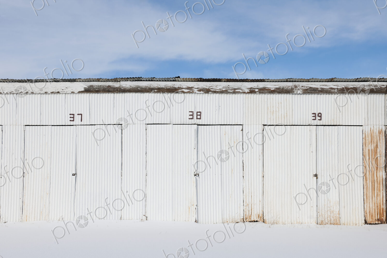Nimbered doors on corrugated metal storage building.