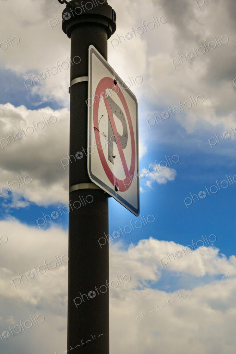 No parking sign, low angle view, clouds in the sky.