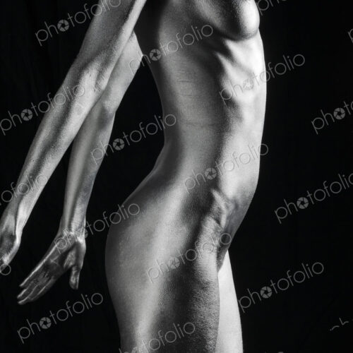 Nude Caucasian woman with silver body paint standing, side view Nude Caucasian woman with silver body paint standing, side view