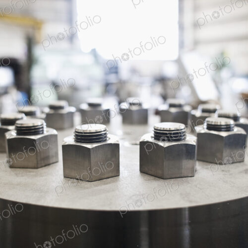 Nuts and bolts on cylinder in workshop.